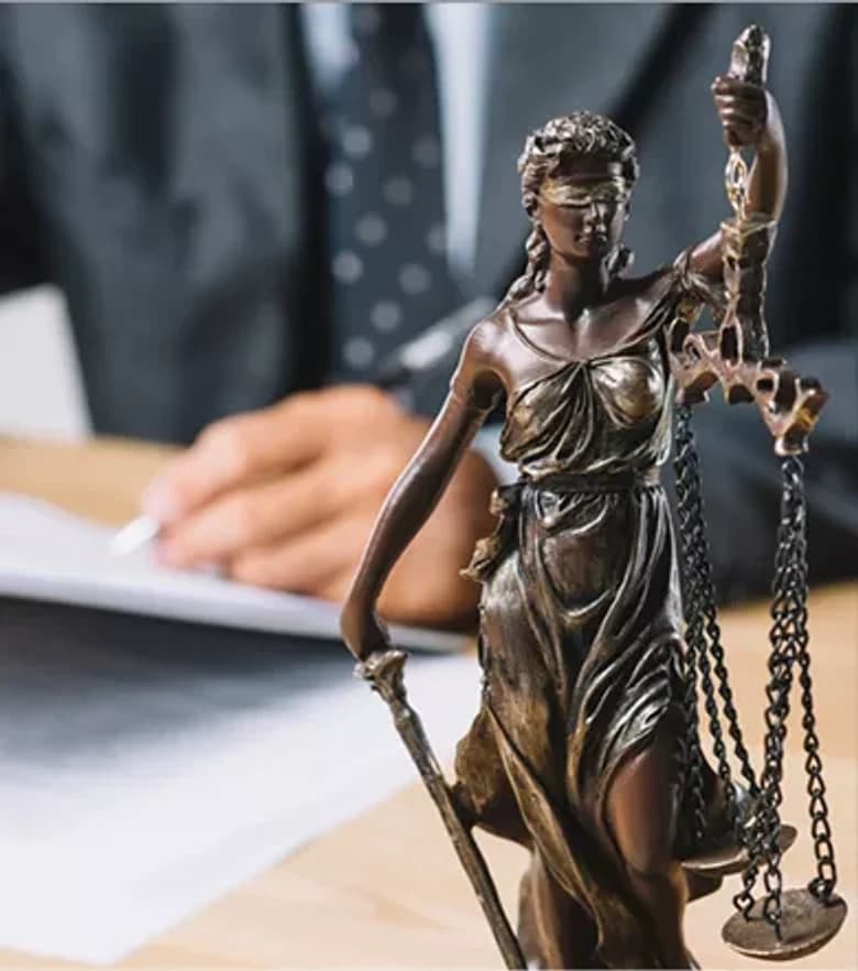 Statue of Lady Justice beside legal papers
